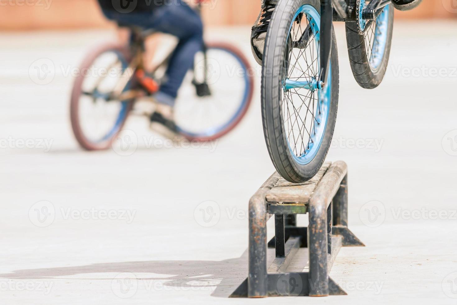 Nahaufnahme von Fahrradrädern, die Trick durch Schiene tun foto