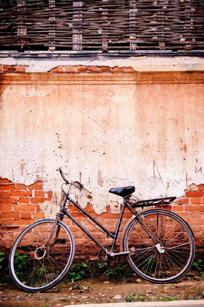 altes Fahrrad geparkt neben dem alten Vintage-Haus. foto