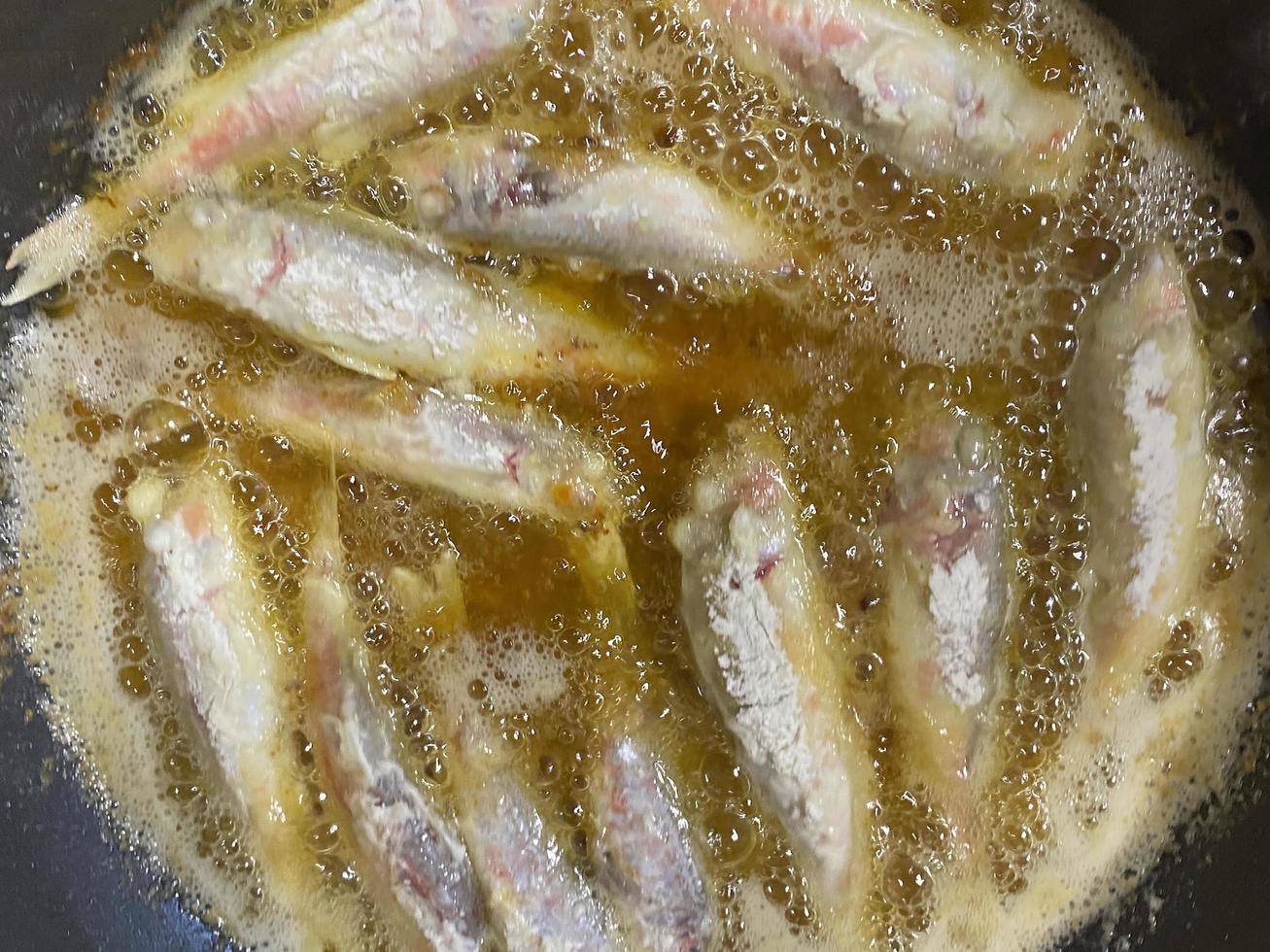 Braten von Meeräschenfischen in heißem Sonnenblumenöl foto