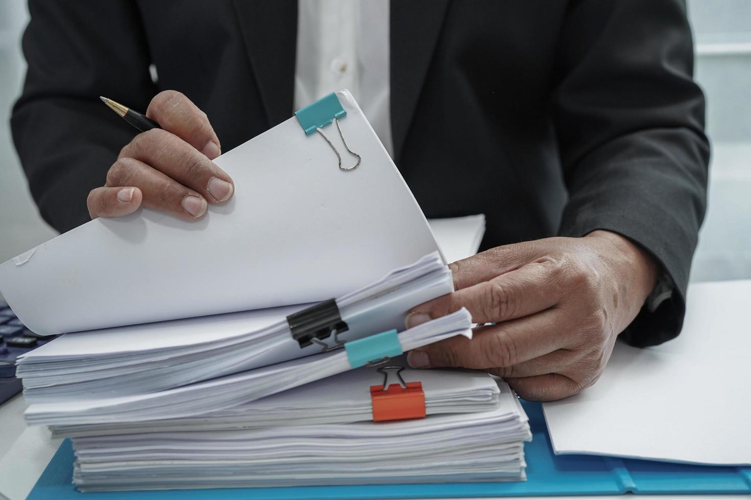 geschäftsmann arbeitet und bereitet papierkramberichtsdaten vor, um informationen im dateiordner im büro zu analysieren. foto