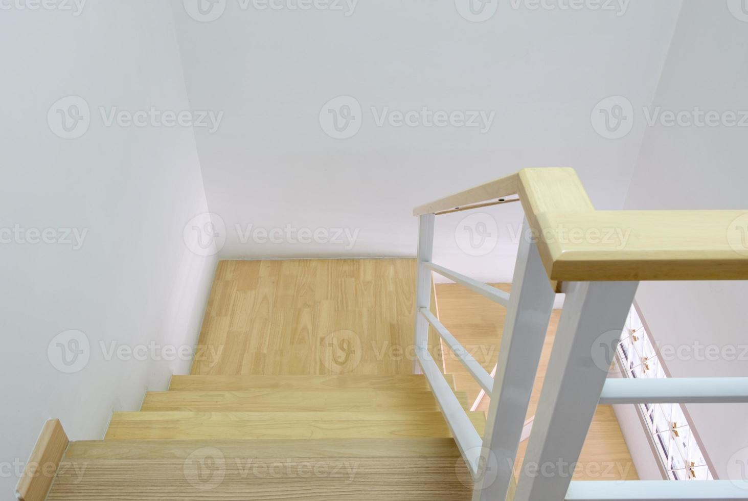 Moderne geschwungene Holztreppe mit Handlauf aus weißem Metall. foto