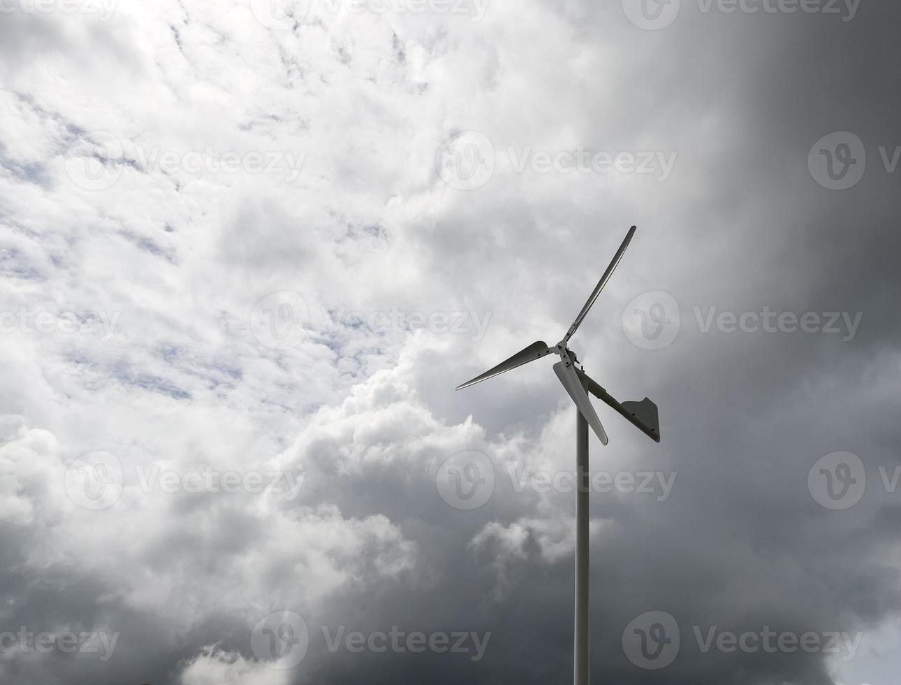 die kleine windkraftanlage unter dem bewölkten himmel im bauernhof auf dem land. foto