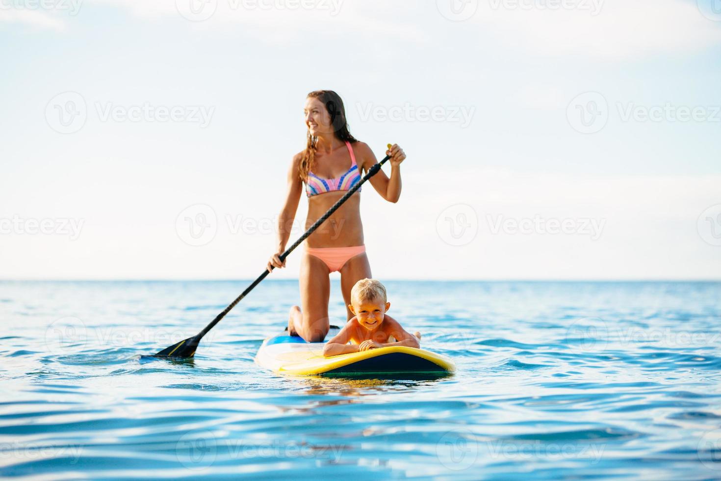 Mutter und Sohn stehen zusammen auf und paddeln foto