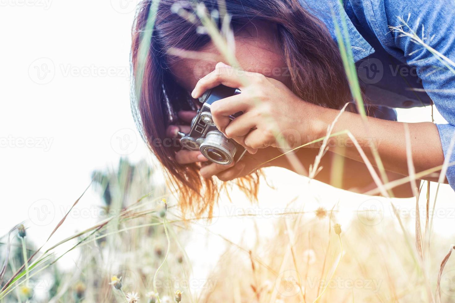 jahrgang der schönen frauenfotografie stehende hand, die retro-kamera mit sonnenaufgang hält, weicher traumstil foto