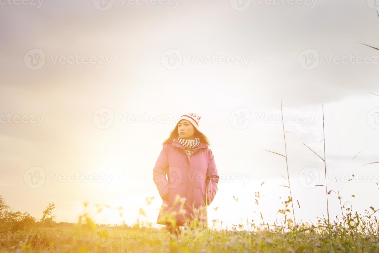 junge Frau spielte in einer Blumenwiese in der Winterluft. foto