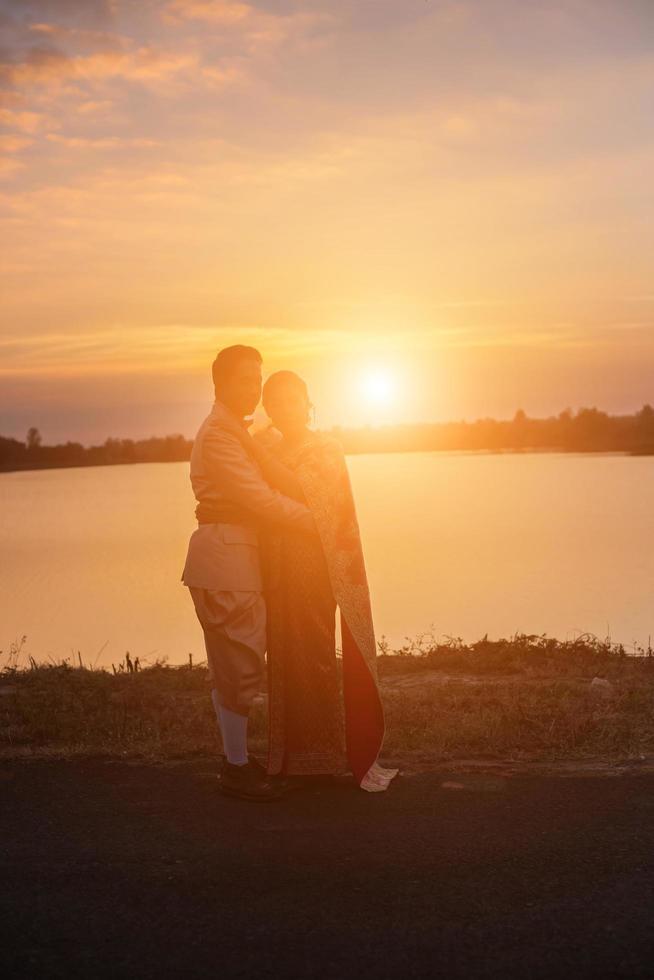 Silhouette von zwei Mädchen, die sich gegenüberstehen, halten die Hände zusammen foto