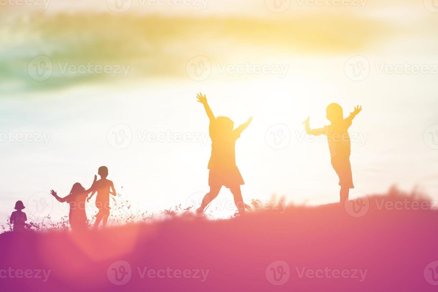 silhouette eines glücklichen kinder- und glücklichen zeitsonnenuntergangs foto