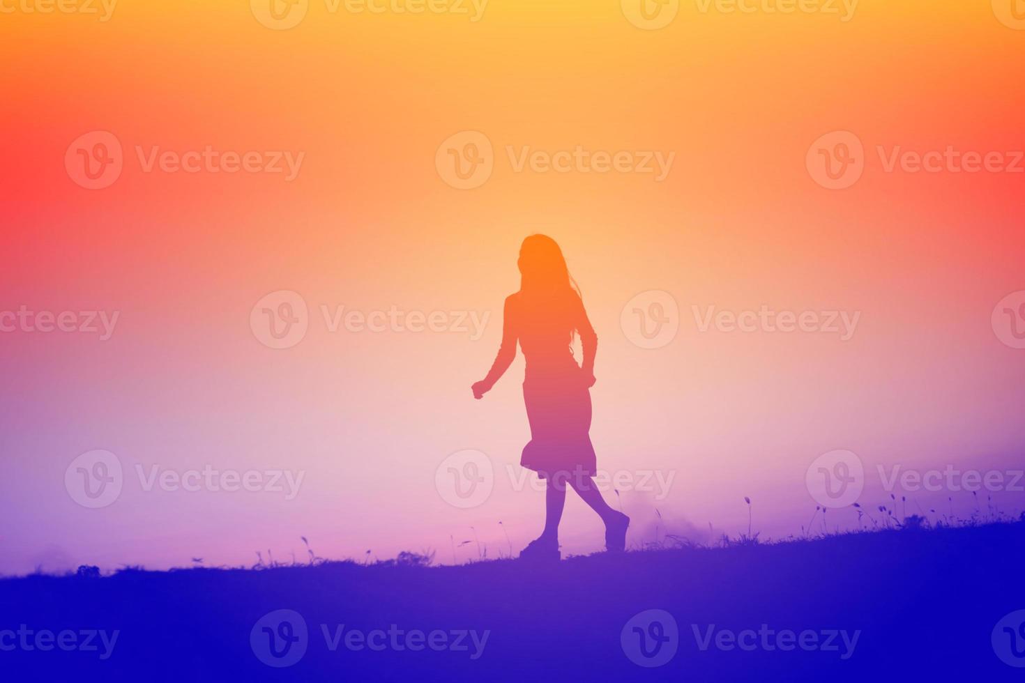 Silhouette einer jungen Frau, die allein steht foto