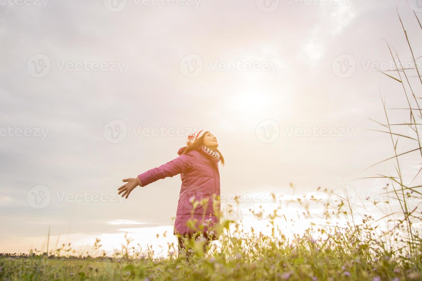 junge Frau spielte in einer Blumenwiese in der Winterluft. foto