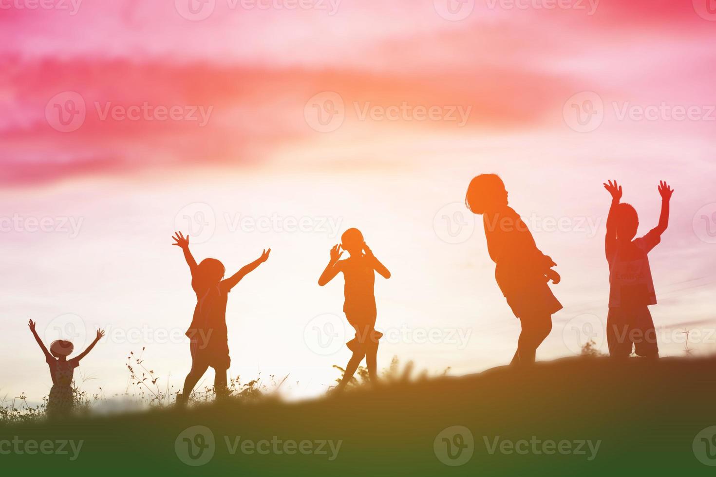 silhouette eines glücklichen kinder- und glücklichen zeitsonnenuntergangs foto