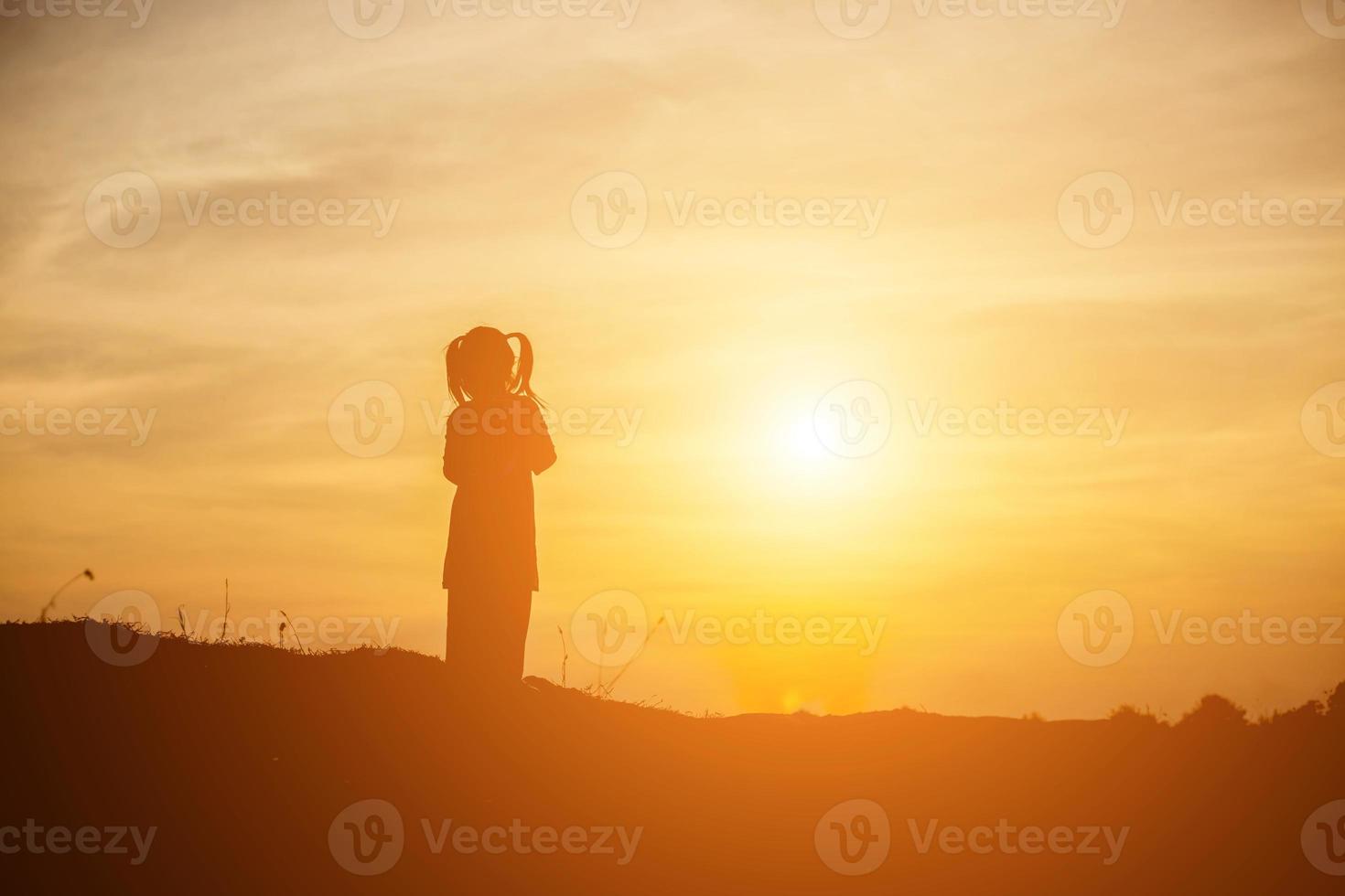 Kindersilhouette, Momente der Freude des Kindes. auf dem natursonnenuntergang foto