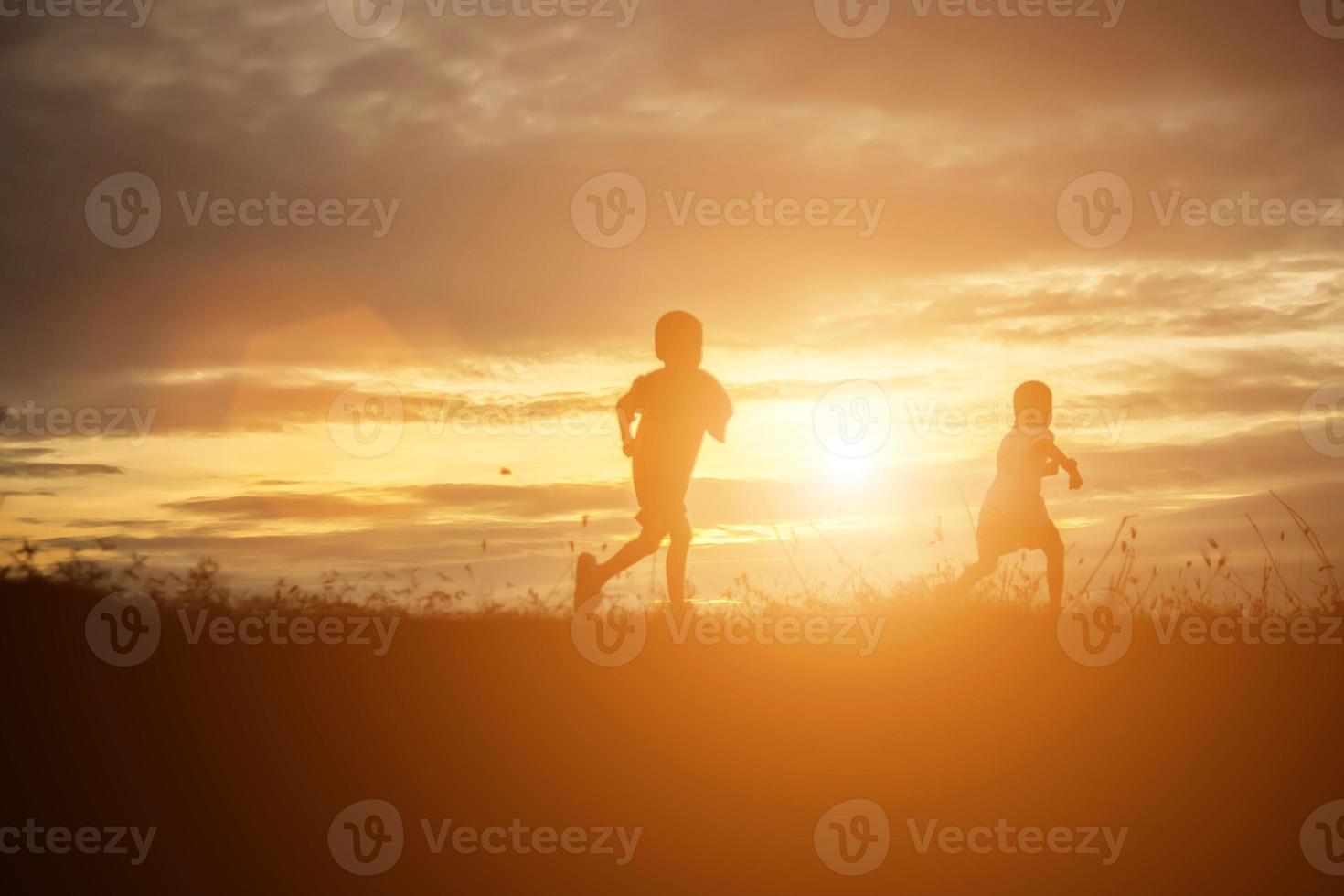 silhouette eines glücklichen kinder- und glücklichen zeitsonnenuntergangs foto