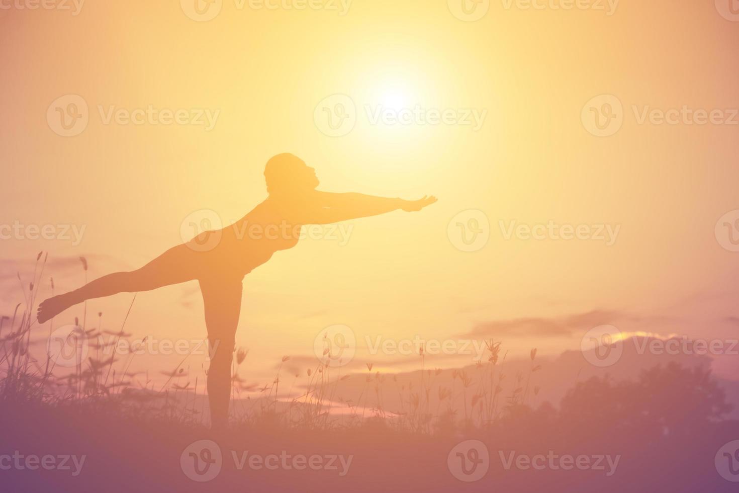 Silhouette einer Frau, die über einem schönen Himmelshintergrund betet foto