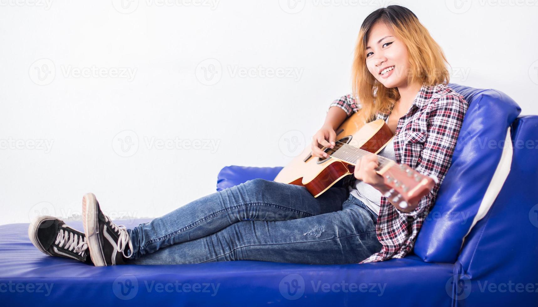 junge Hipster-Frau, die eine Gitarre spielt. foto