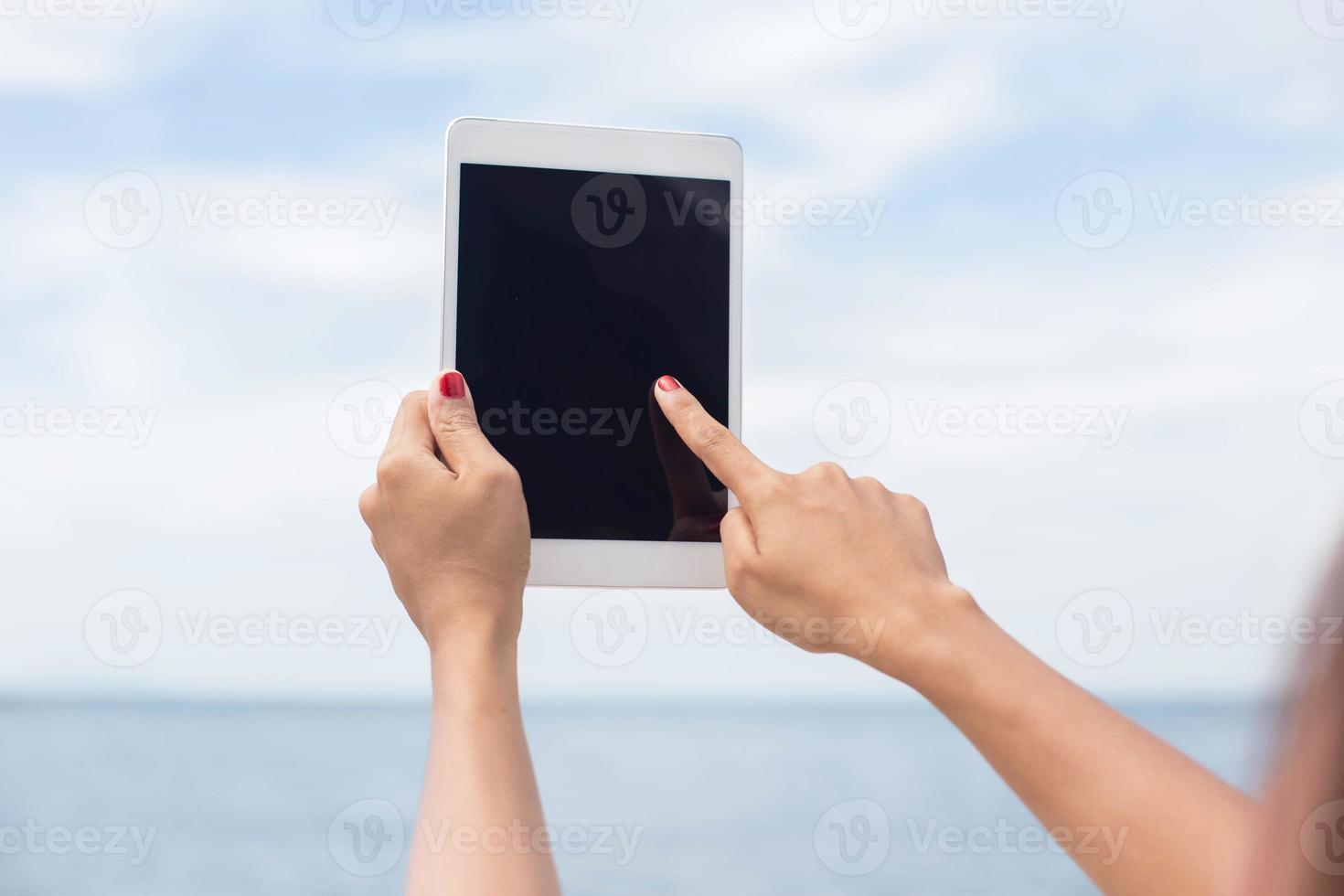 junge frau, die am cafétisch mit digitalem tablet sitzt foto