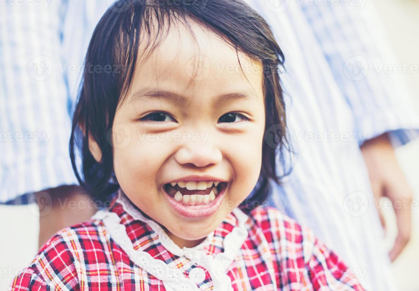 Porträt eines glücklich lächelnden, süßen kleinen Mädchens im Freien am Sommertag foto