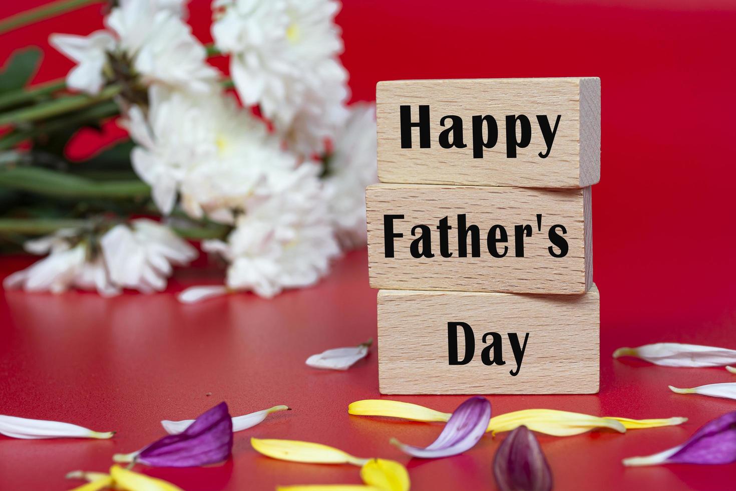 Text auf Holzwürfel und mit Blume auf rotem Grund - glücklicher Vatertag foto