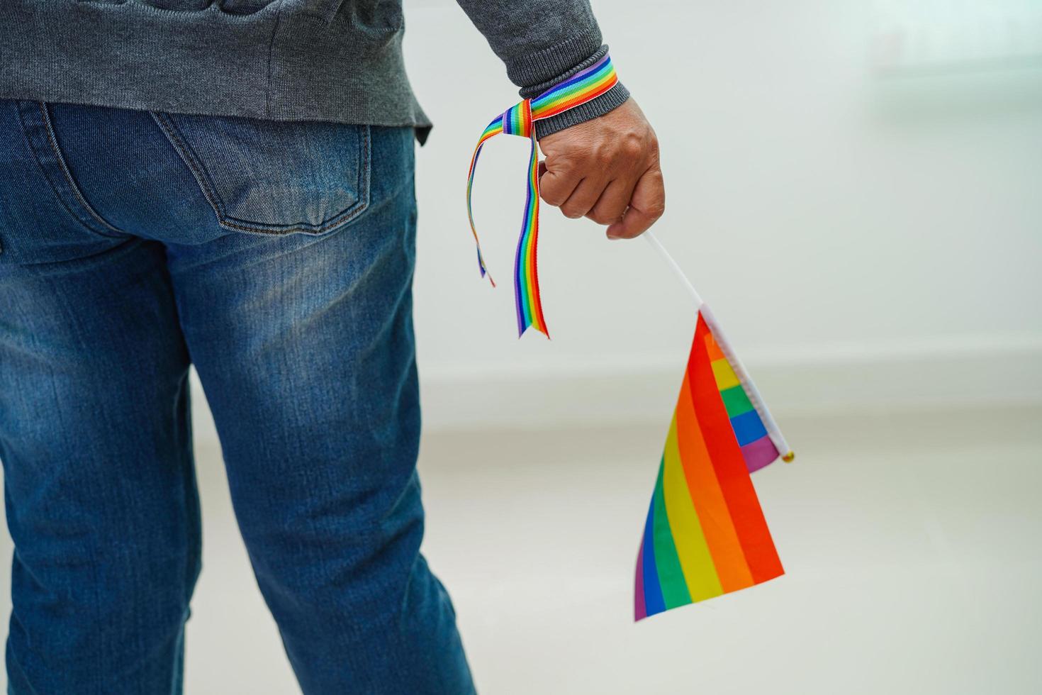 asiatische frau mit regenbogenflagge, lgbt-symbolrechten und geschlechtergleichstellung, lgbt-stolzmonat im juni. foto