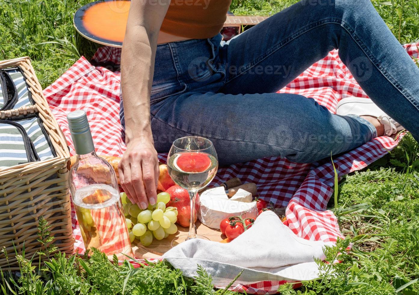 unerkennbare junge frau im park draußen an einem sonnigen tag, genießt den sommer, träumt und trinkt wein foto