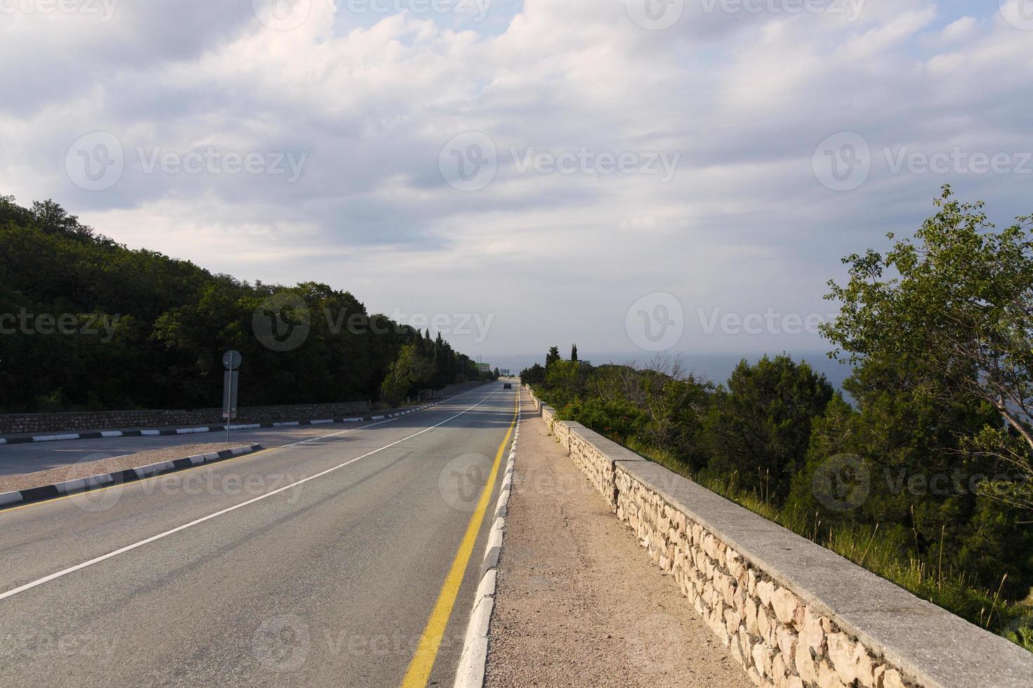 europäische autobahn mit markierungen in den bergen, die im morgengrauen zum meer führen. Küste des Schwarzen Meeres. foto