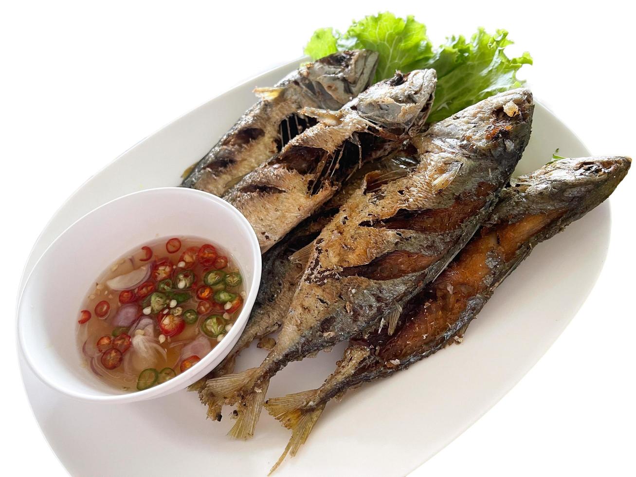 isolierte gebratene kurze Makrele, serviert mit Paprika-Fischsauce. asiatisches essen, beliebtes thailändisches meeresfrüchtemenü. foto