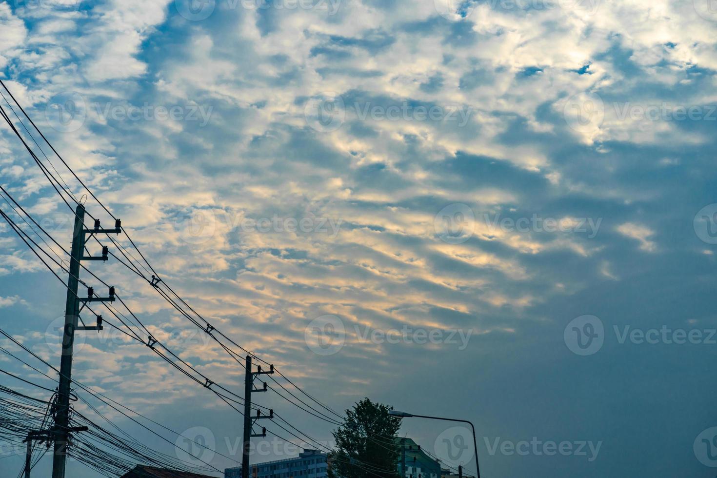 wolken- und goldlicht mit stromkabel in der dämmerungszeit foto