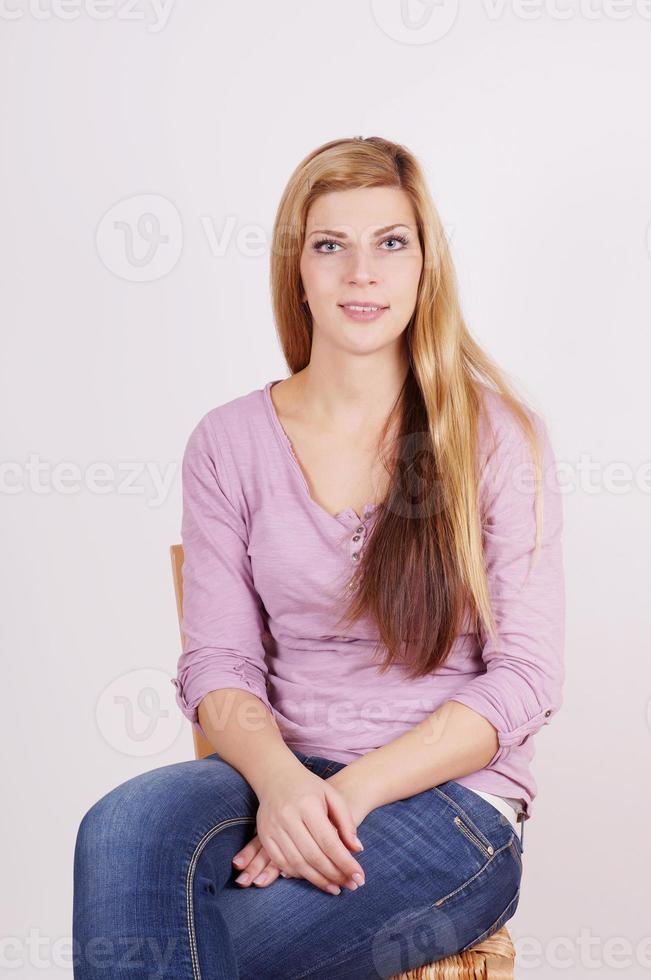 junge Frau sitzt auf Stuhl foto