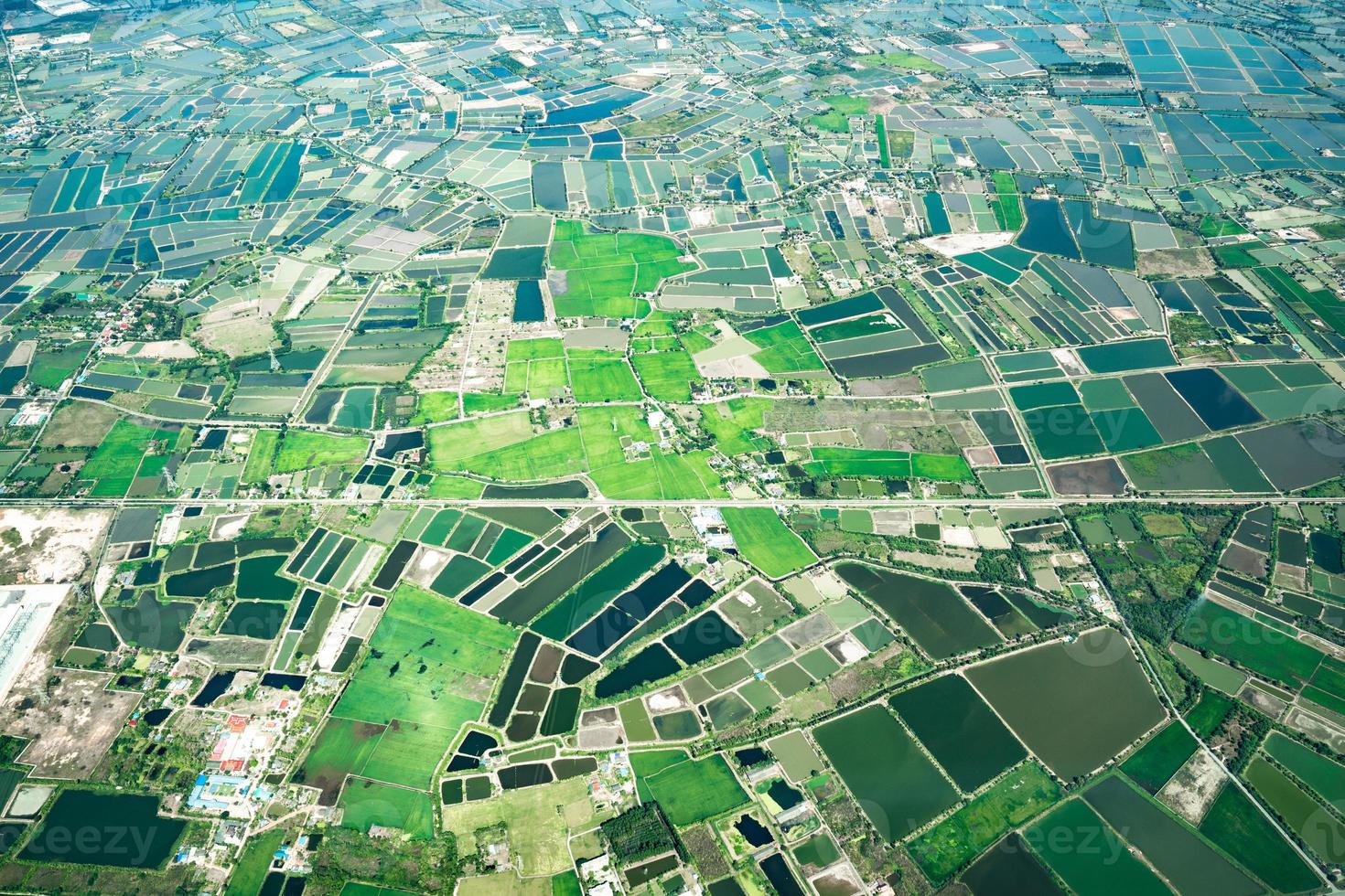 der blick auf die grüne wiese und den bauernhof und die innenstadt der stadt mitten in thailand. es schoss aus dem Düsenflugzeug. foto