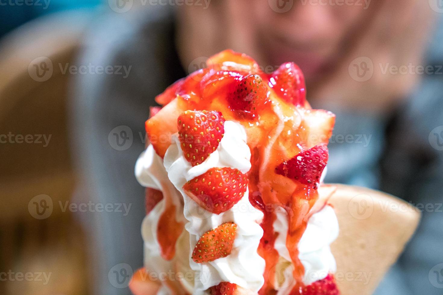 Erdbeer-Eisbecher-Turm-Eis mit Schlagsahne und Erdbeersoße. foto