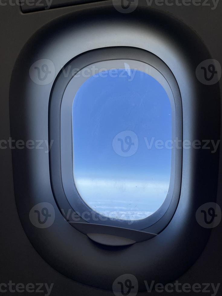 Flugzeugfenster mit blauem Himmel. foto