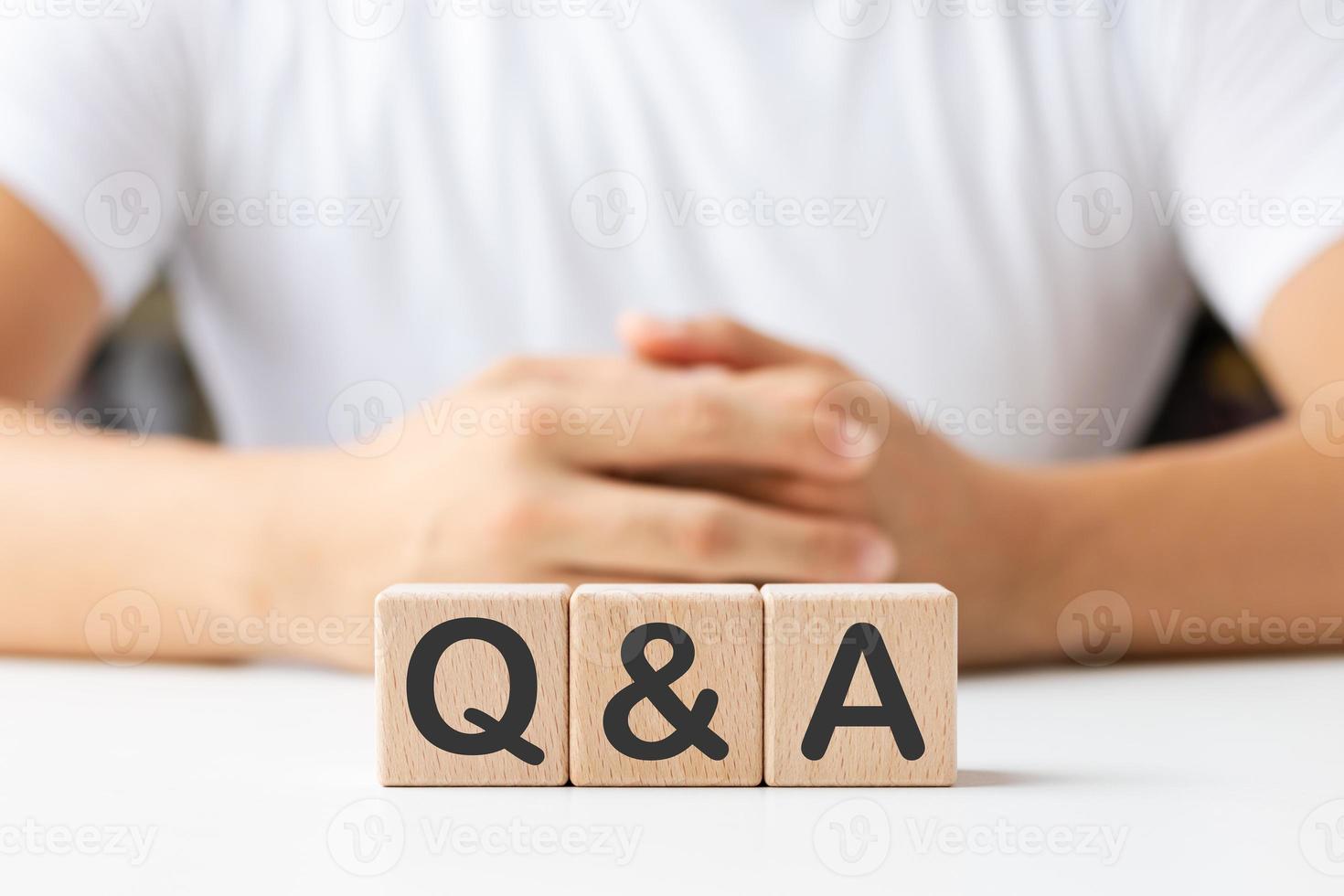 Hand, die q und a-Wörter mit Holzwürfelblöcken hält, Antworten, Fragen stellen, Informationen, häufig gestellte Fragen. foto