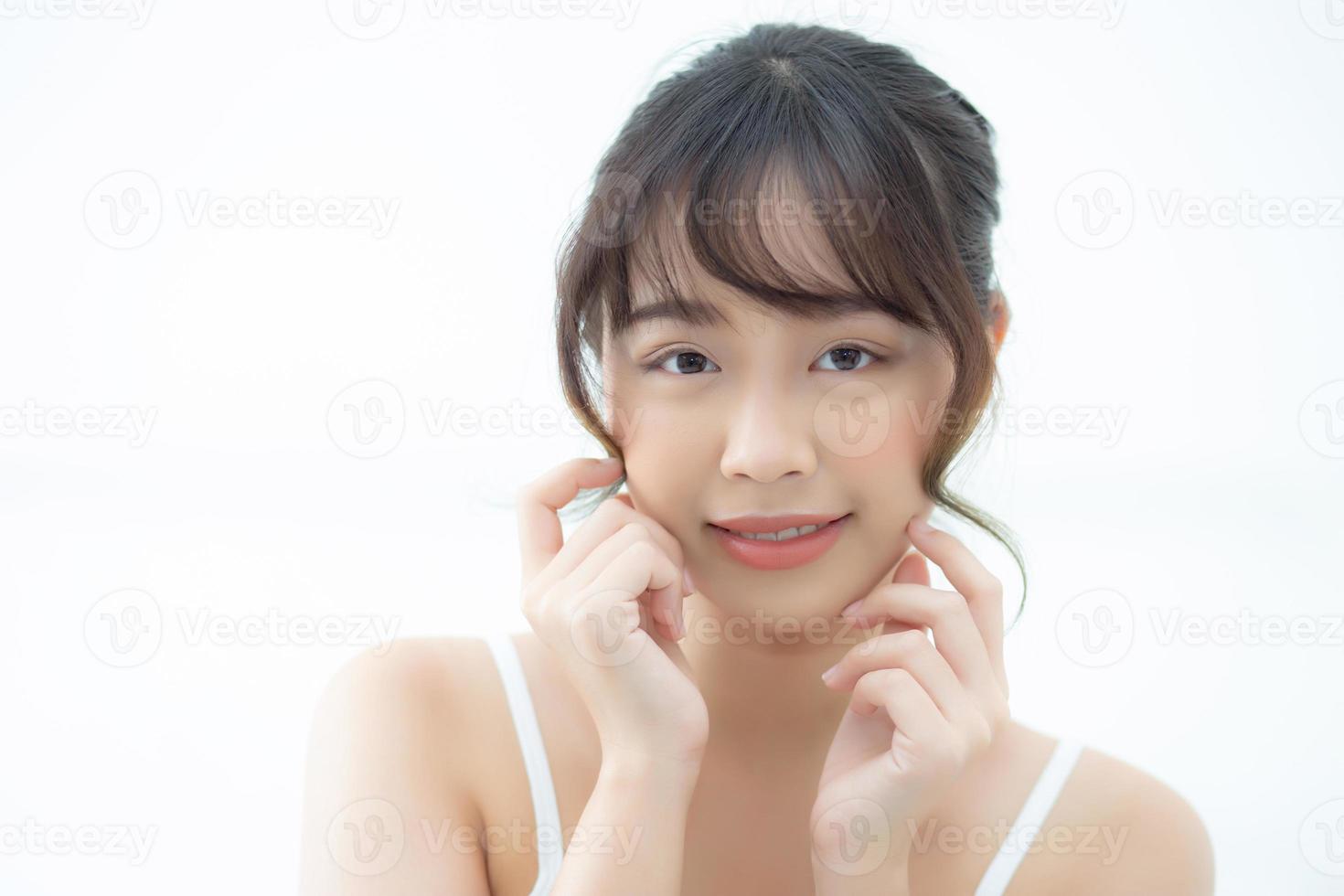 porträt schöne asiatische frau make-up von kosmetik, mädchenhand berühren wange und lächeln attraktiv, gesichtsschönheit perfekt mit wellness im schlafzimmer zu hause mit hautpflege- und gesundheitskonzept. foto