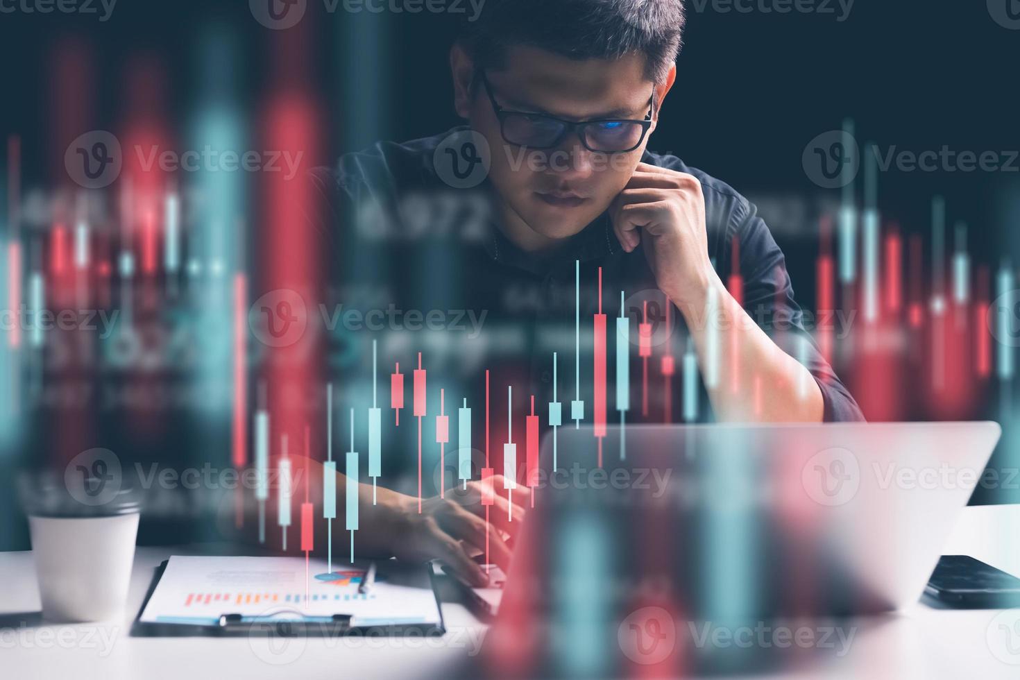 geschäftsmann, der im büro arbeitet, technisches preisdiagramm und roter und grüner kerzenhalter-diagrammindikator und computerbildschirmhintergrund für den aktienhandel, doppelbelichtungshändler analysieren daten. foto