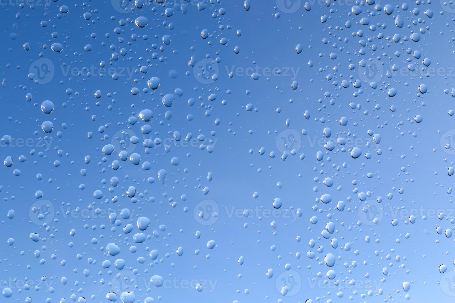 Regentropfen, die ein Fenster in einer Nahaufnahme herunterlaufen. foto