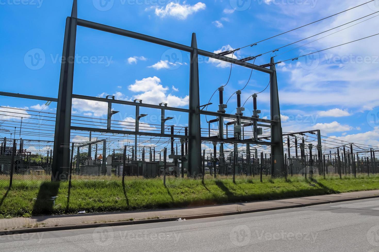 elektrischer Transformator. Verteilung der elektrischen Energie an einem großen Umspannwerk mit vielen Stromleitungen an einem sonnigen Tag foto