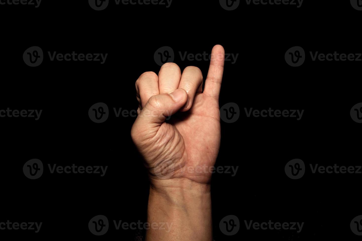 Die Hand des Mannes, die den kleinen Finger hält, zeigt das Symbol eines Vertrags oder einer Bitte um Versöhnung auf schwarzem Hintergrund. foto