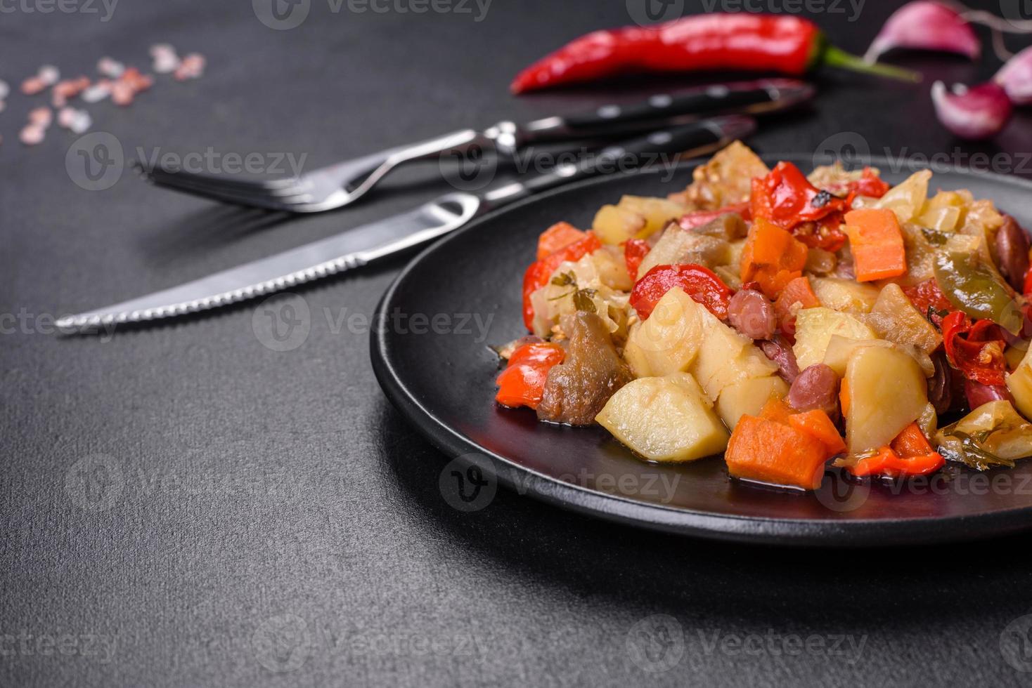 Gemüseeintopf oder Ratatouille mit Auberginen, Tomaten, süßen und scharfen Paprika, Zwiebeln, Karotten und Gewürzen in der Platte foto