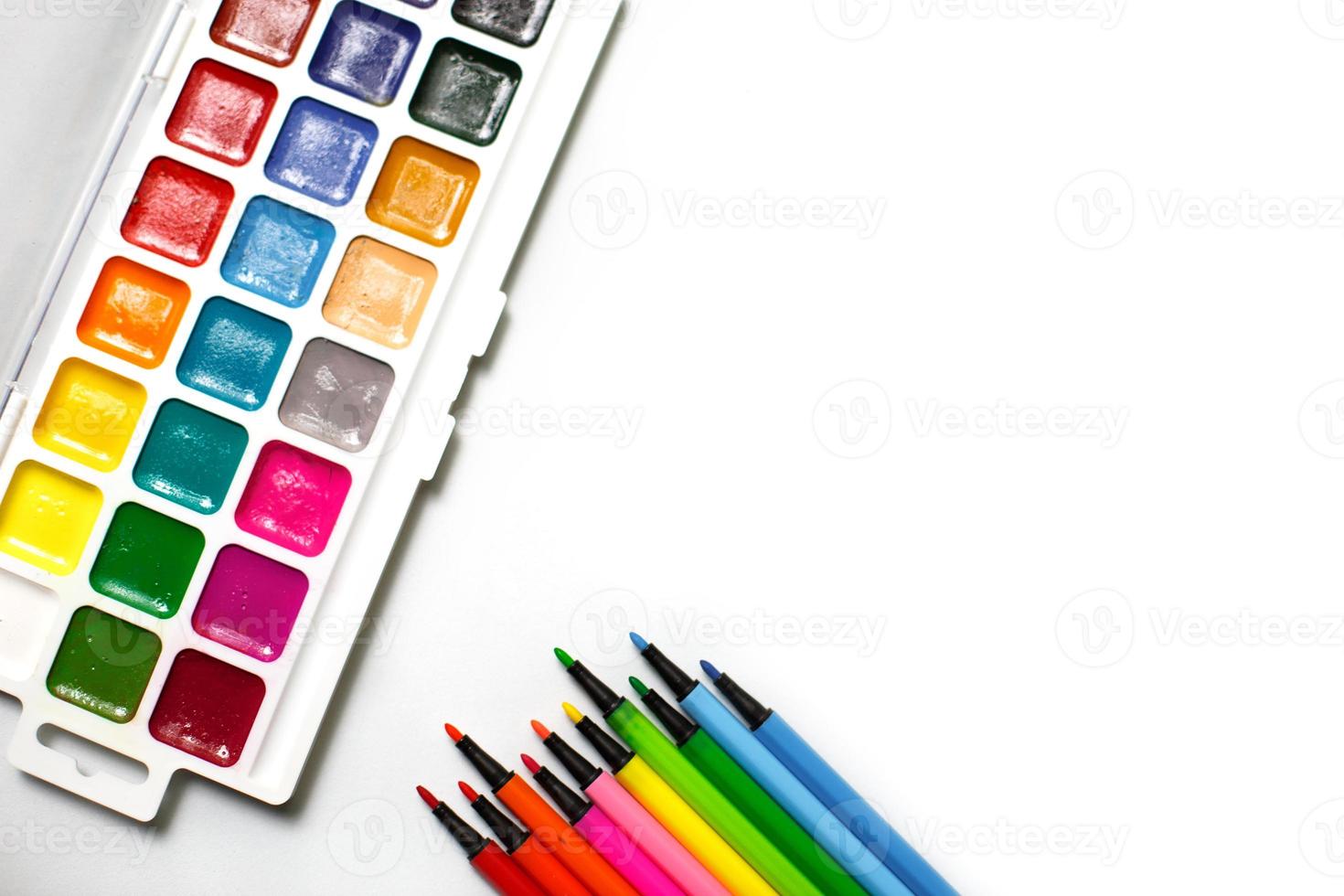 Eine Palette von Farbaquarellen mit Pinseln und Markern auf weißem Hintergrund mit Platz für Text. foto