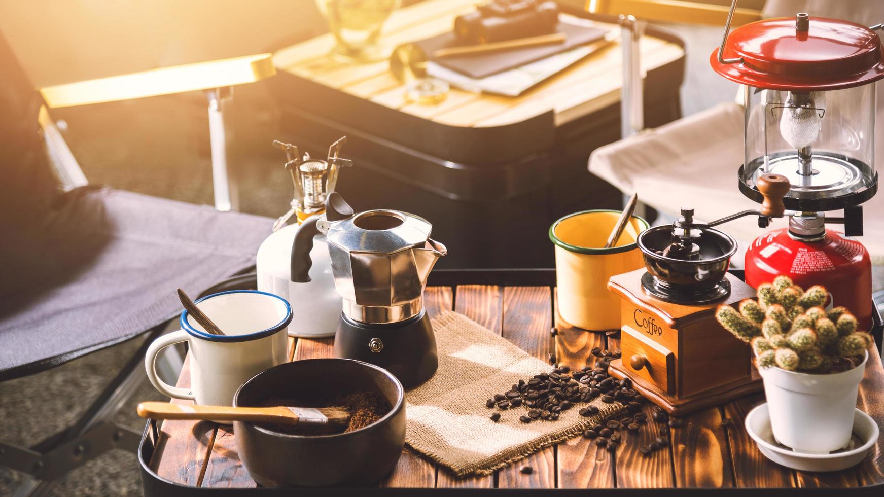 Tasse Kaffee, Bohnenröten und Zutaten für die Zubereitung von Kaffee und Zubehör auf dem Holzhintergrund des Tisches. Konzept für die Kaffeezubereitung foto