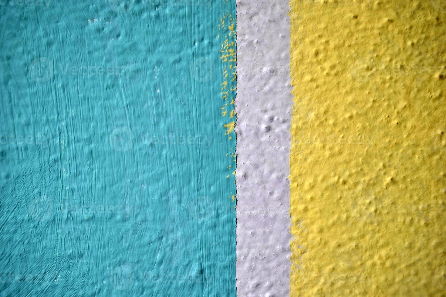 eine gelbe und blaue Wand, die mit Streifen und einem Dreieck bemalt ist foto