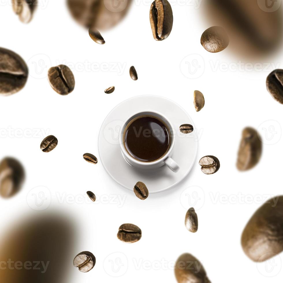 Tasse Kaffee und Kaffeebohnen im Flug auf weißem Hintergrund foto