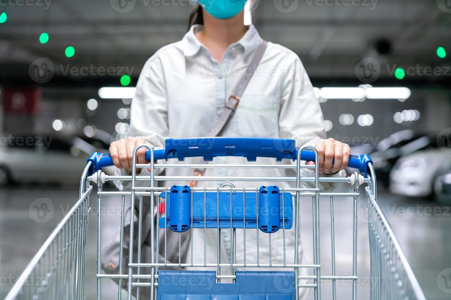 glückliche Frau mit Nahaufnahme-Einkaufswagen oder Trolley auf dem Parkplatz von frischem Maket für gesunde Hausfrau im Supermarkt foto