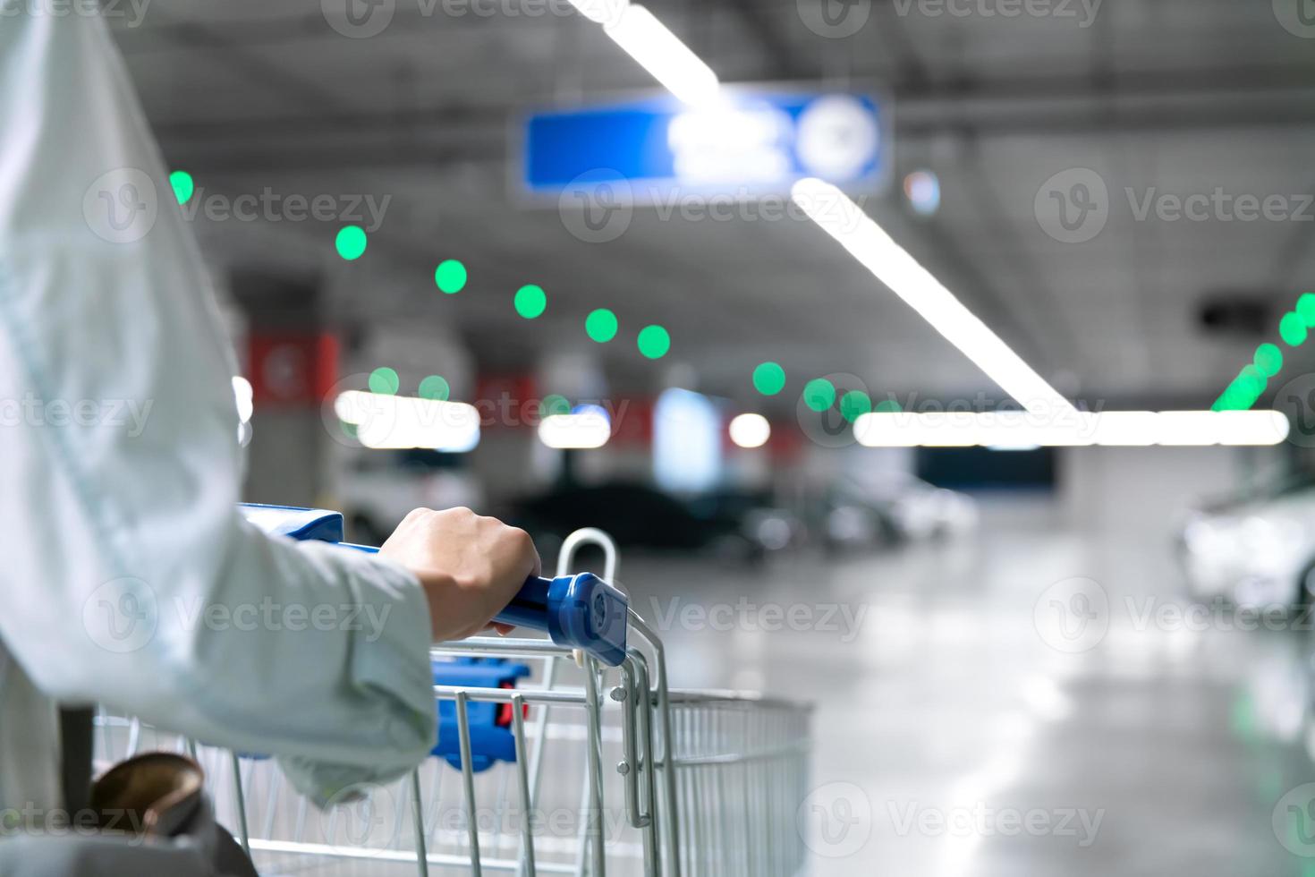 glückliche Frau mit Nahaufnahme-Einkaufswagen oder Trolley auf dem Parkplatz von frischem Maket für gesunde Hausfrau im Supermarkt foto