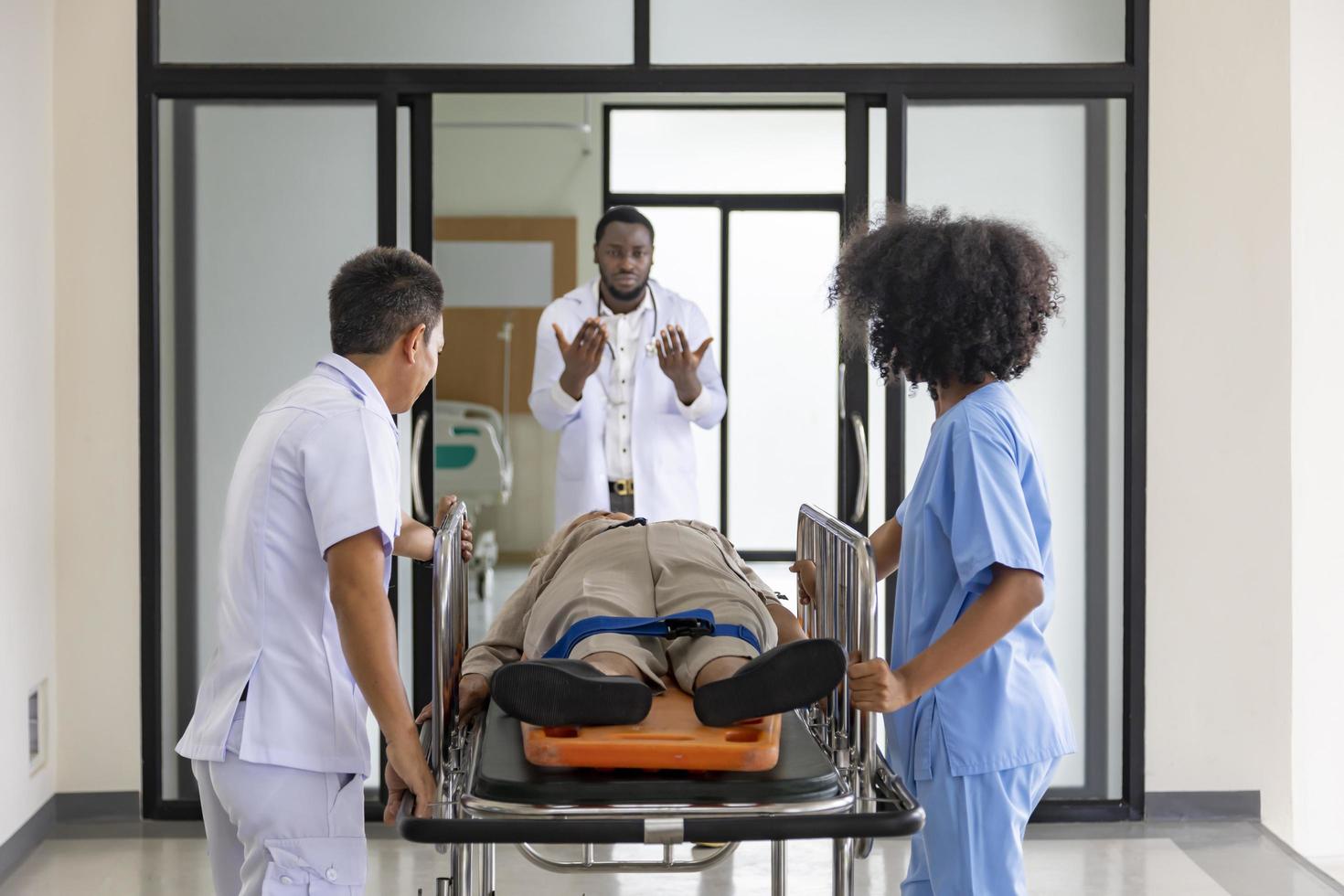 Der Arzt leitet das Sanitäterteam, um den Patienten von einem Autounfall in die Notaufnahme im Krankenhaus zu bringen foto