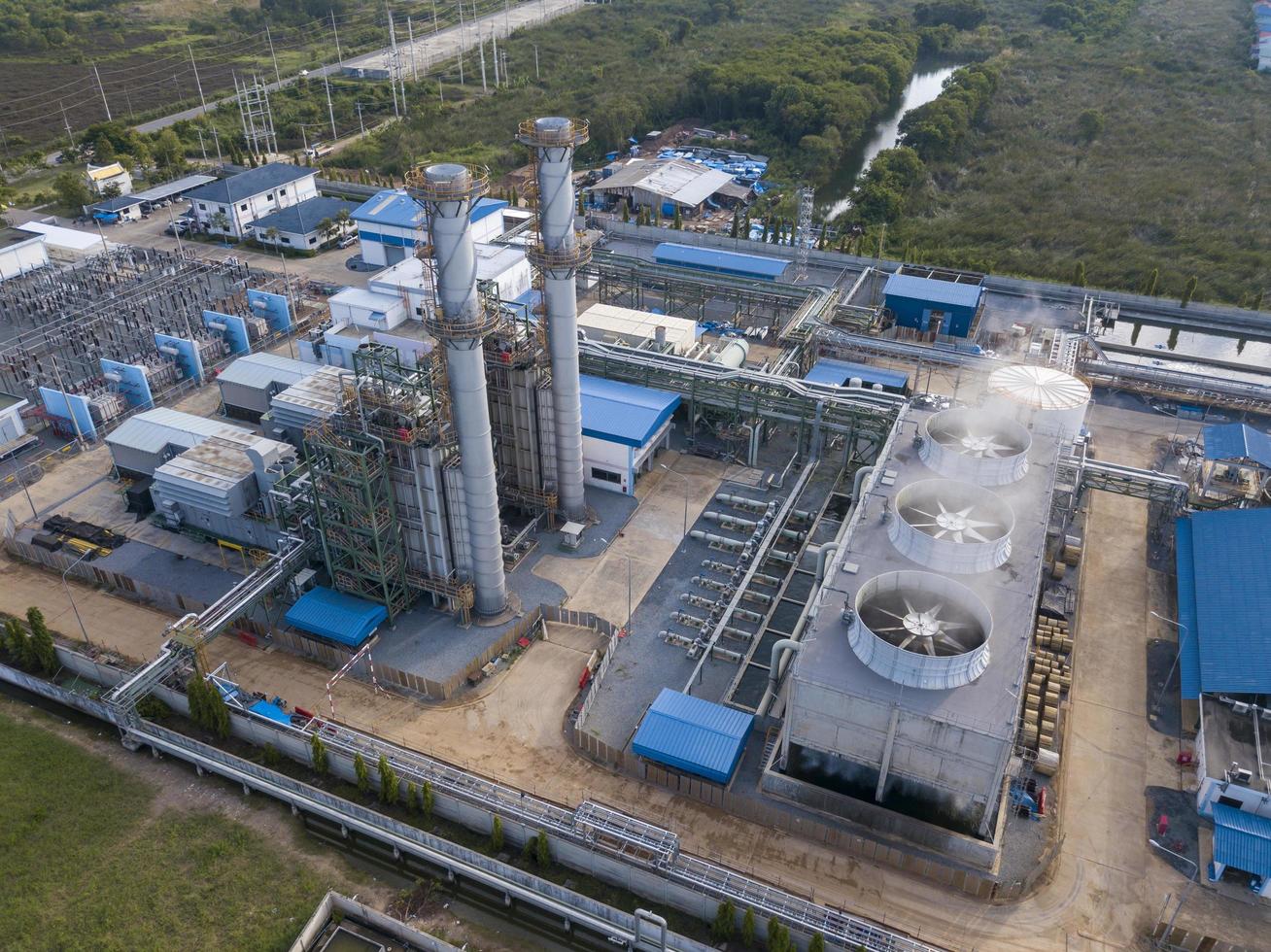 Luftaufnahme der Gasturbinenkraftwerksfabrik mit Kühlsystemlüfter in Betrieb, der Strom produziert, während er Umweltverschmutzung verursacht und Kohlendioxid freisetzt, das die globale Erwärmung verursacht foto