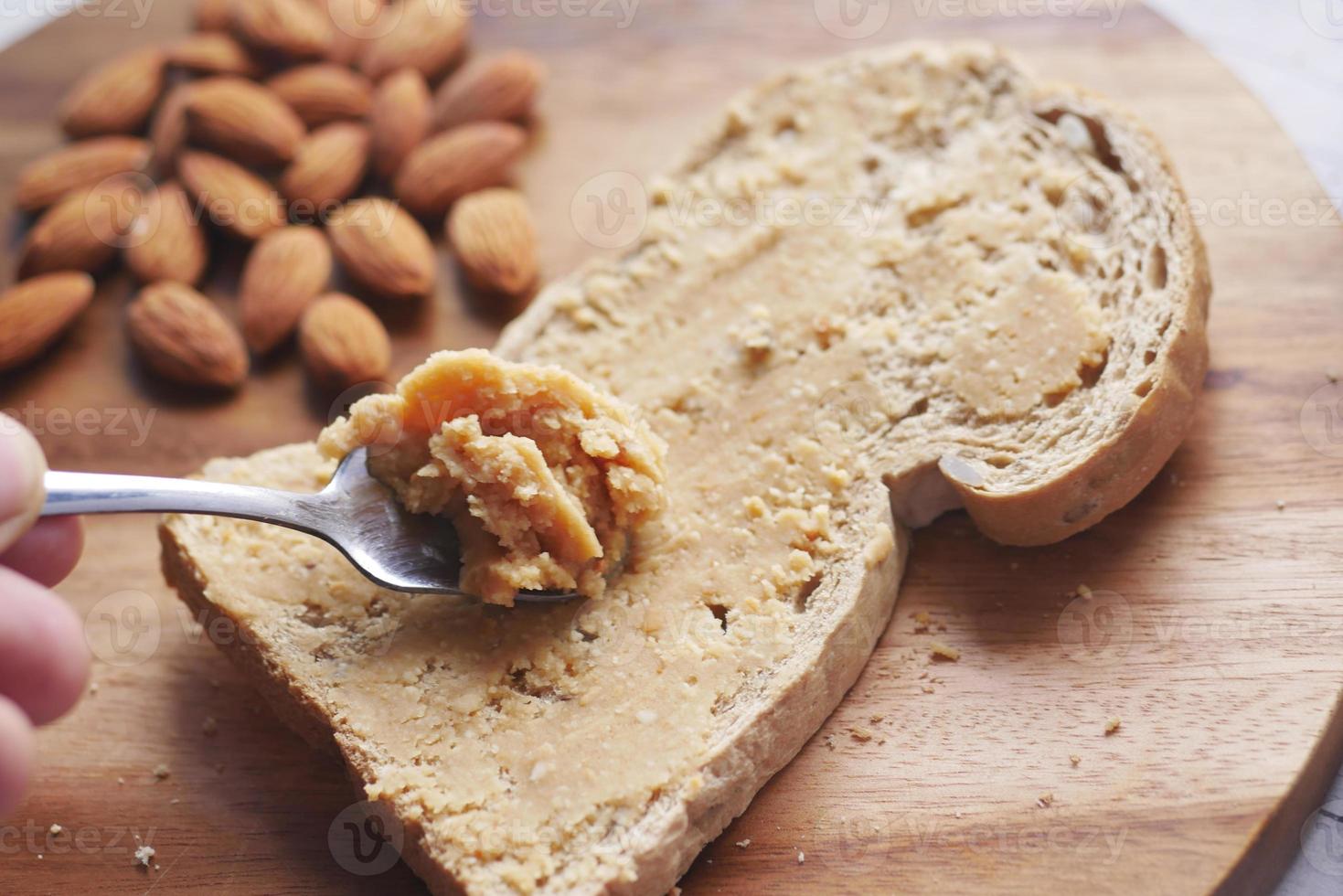 Mandelbutteraufstrich auf einem Schwarzbrot auf dem Tisch foto