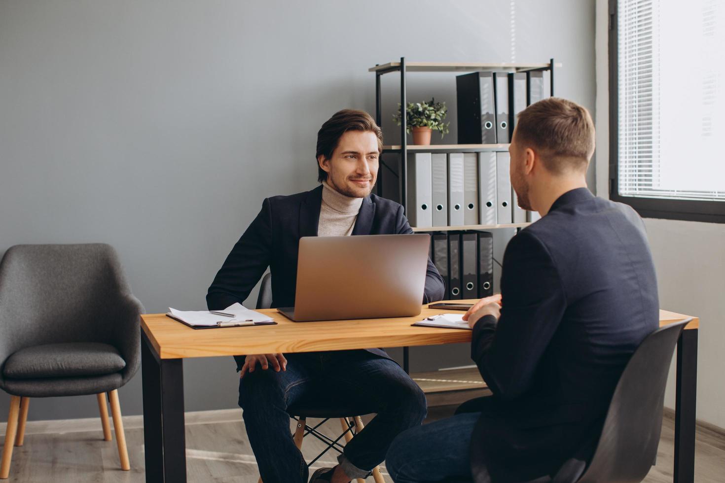 Personalvermittler während eines Vorstellungsgesprächs im Büro mit einem männlichen Kandidaten foto