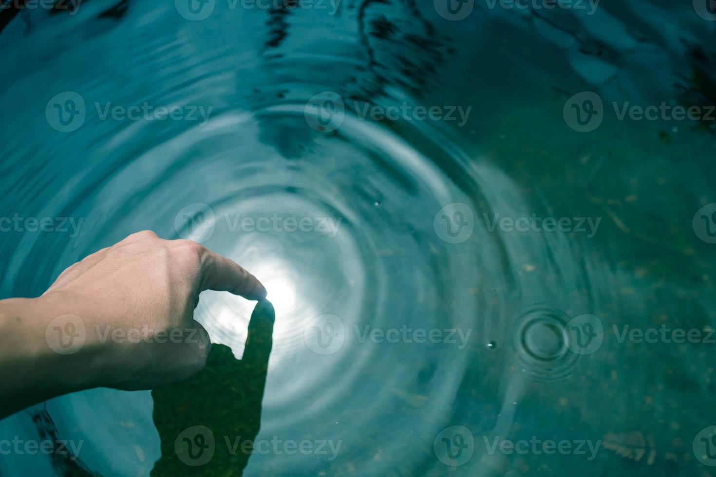 Die Hände tauchten in blaues Wasser bis zu den Wellen. foto