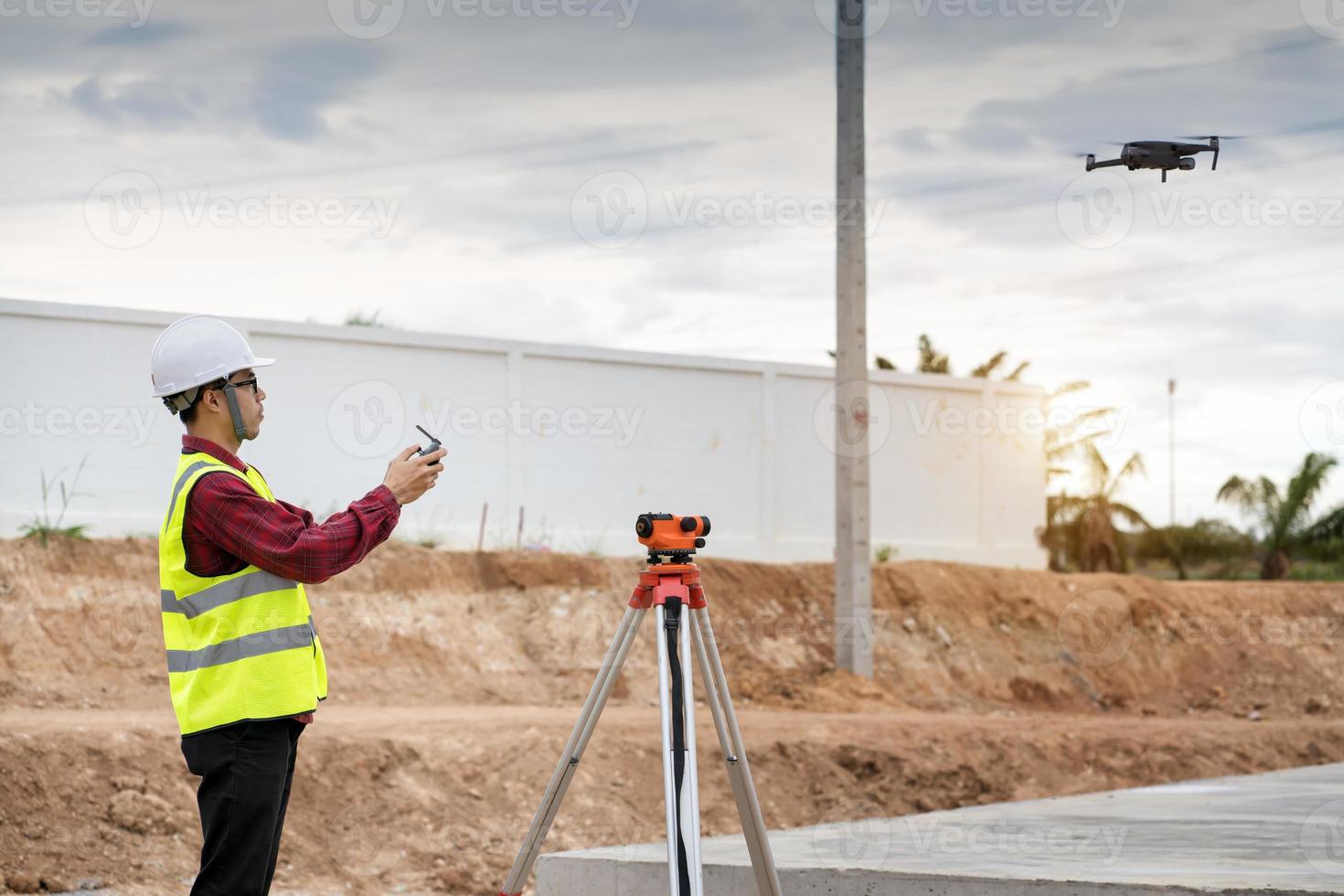 Vermessungsingenieur, der auf der Baustelle mit Theodolit arbeitet foto