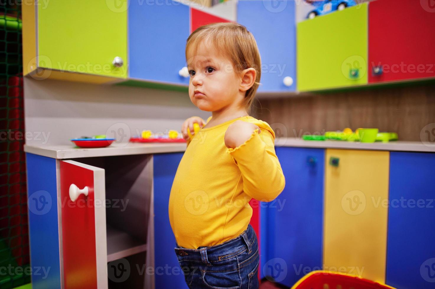 süßes kleines Mädchen, das im Indoor-Spielzentrum spielt. Kindergarten oder Vorschulspielzimmer. in der Kinderküche. foto